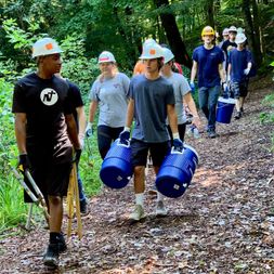  Volunteers along trail carrying water jugs and tools